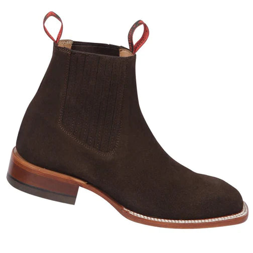 A brown suede chelsea boot with a low heel and red detailing on the side.