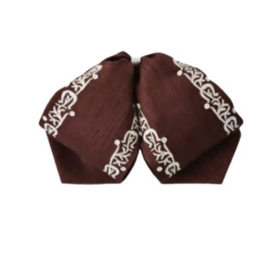 A traditional Mexican charro hat with white diamond embroidery on a dark background.