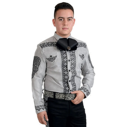 A man wearing a traditional Charro shirt with embroidery and unique buttons, predominantly gray in color, paired with black trousers.