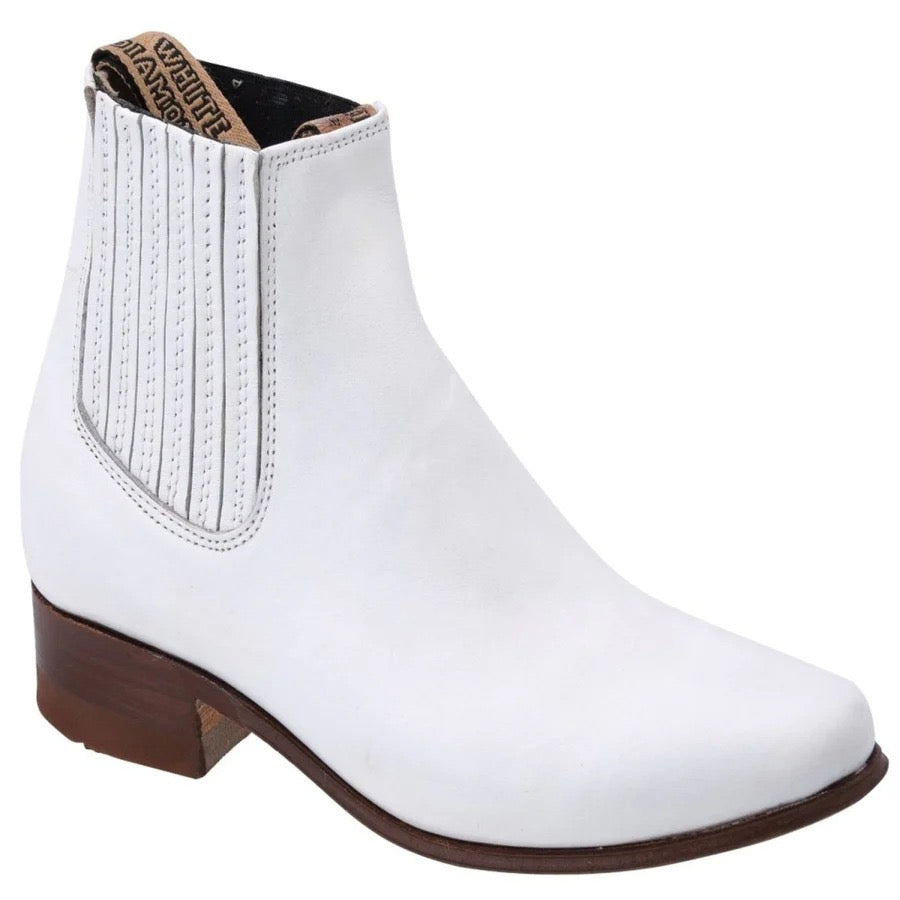 White ankle boot with brown sole on a white background