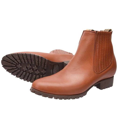 A pair of brown leather Charro ankle boots for men with a round toe and traditional low heel, showing the side profile and sole.