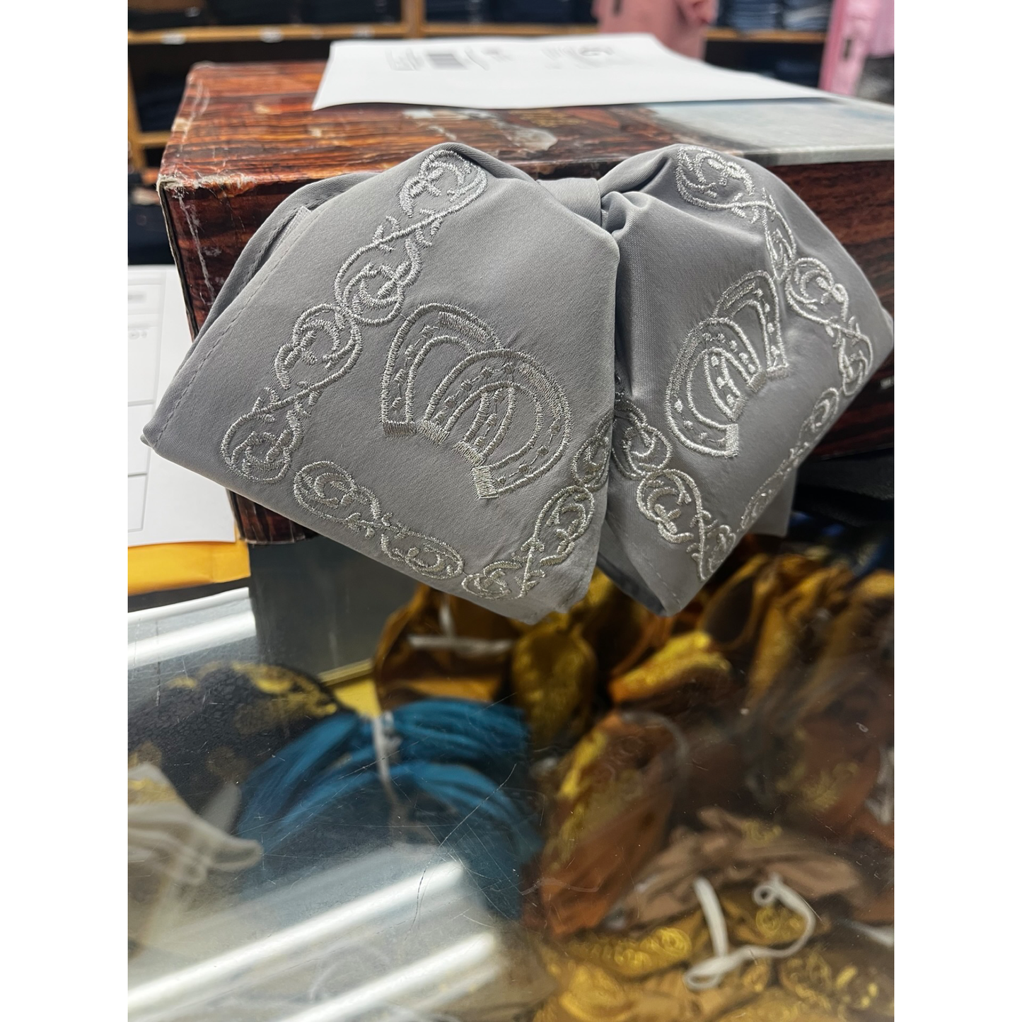 Gray fabric with embroidered patterns on a wooden surface