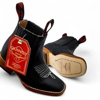 Black ankle boots with a red tag on a white background