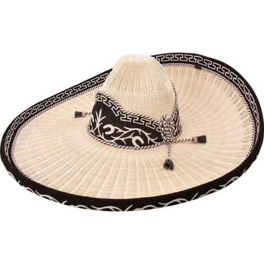 A traditional Mexican sombrero with a white brim and black diamond pattern, featuring a decorative black and white band and a tassel.