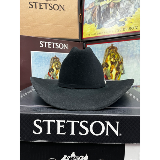 Black Stetson hat on a Stetson branded box with a horse and rider illustration.