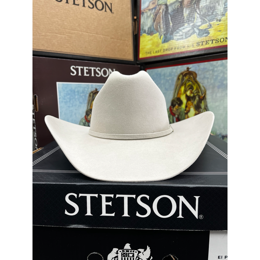 White Stetson cowboy hat on a Stetson branded box with vintage-style packaging in the background.