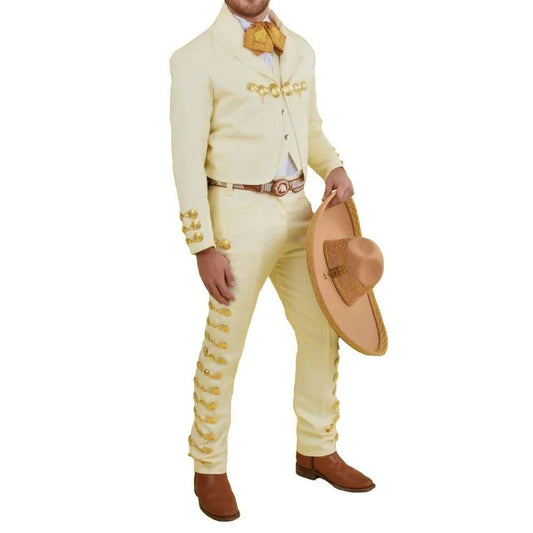 Man wearing a cream-colored suit with gold accents, holding a sombrero on a white background