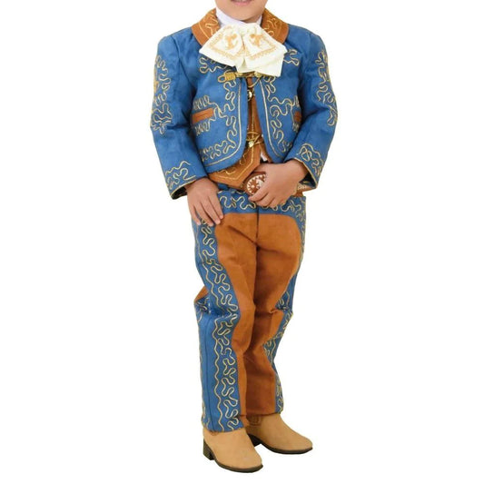 A young boy wearing a traditional charro suit with blue embroidered jacket, brown pants, and beige boots.