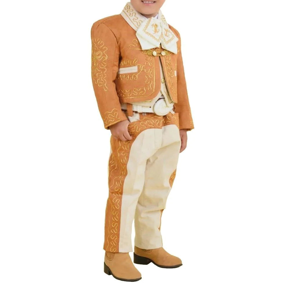 A young boy wearing a traditional charro suit with embroidery and button details, including a white shirt, pants, a jacket, and boots.