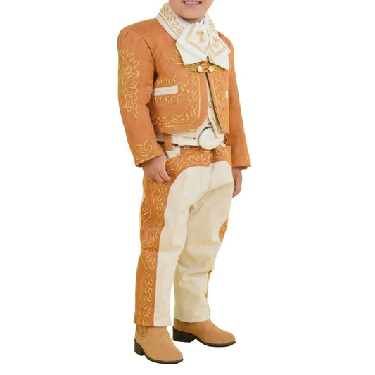 A young boy wearing a traditional charro suit with embroidery and button details, including a white shirt, pants, a jacket, and boots.