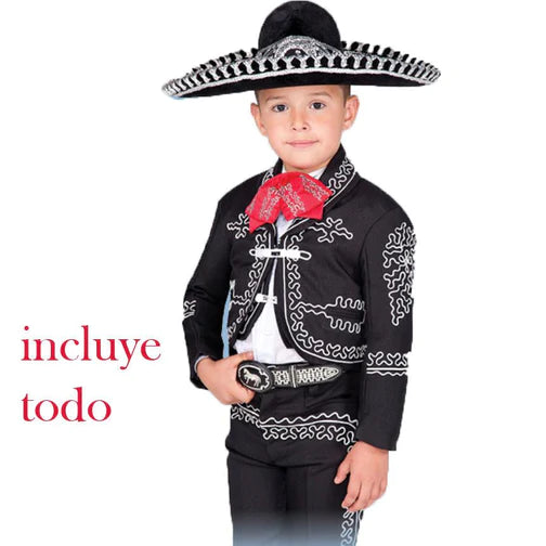 A young boy wearing a traditional charro outfit which includes a black jacket with white embroidery, a white shirt, a black sombrero, and a red bandana.