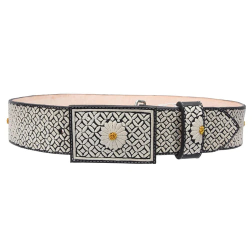 A traditional Mexican piteado belt with white diamond pattern and floral embroidery, featuring a metallic buckle.